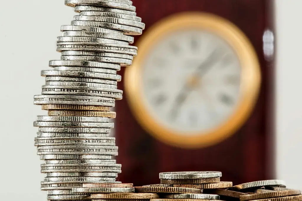 A pile of coins in front of a large clock for the section "How much does a doggy daycare cost in Auckland?"
